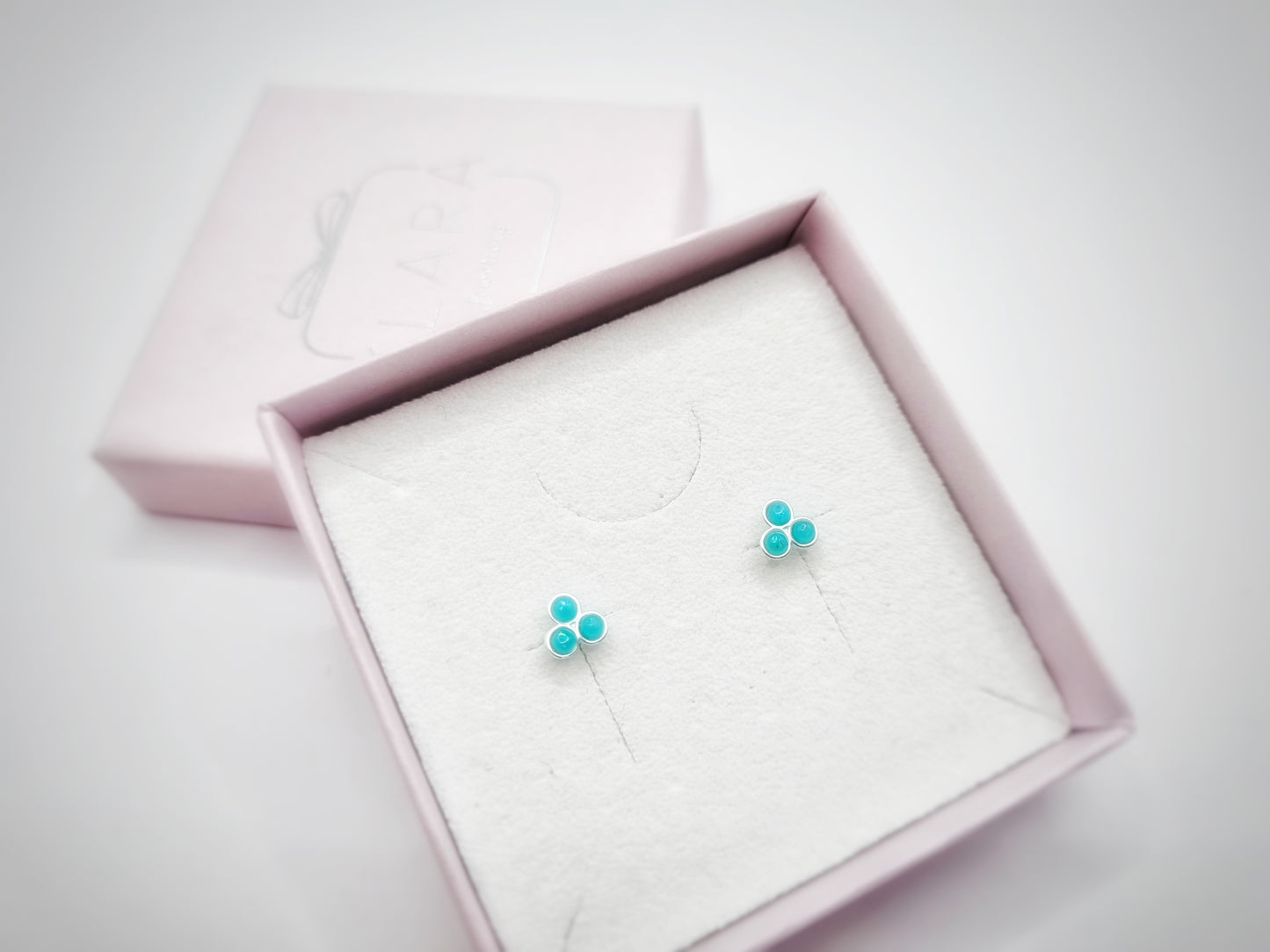 A pair of green opal stud earrings featuring three semi-precious dots, representing the December birthstone